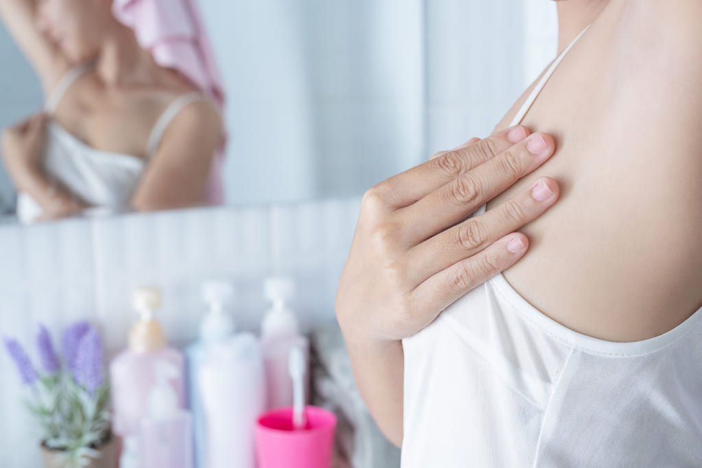 mujer después de aplicarse desodorante en crema